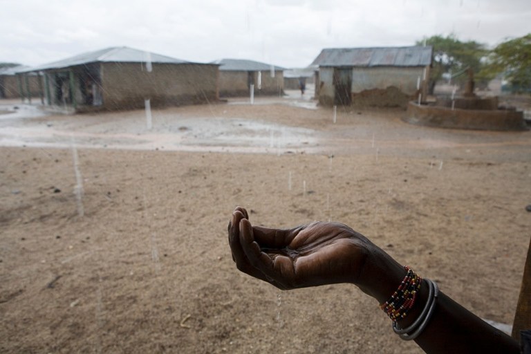 A hand is held out to feel the precious drops of rain